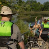 people loading kayaks into the water